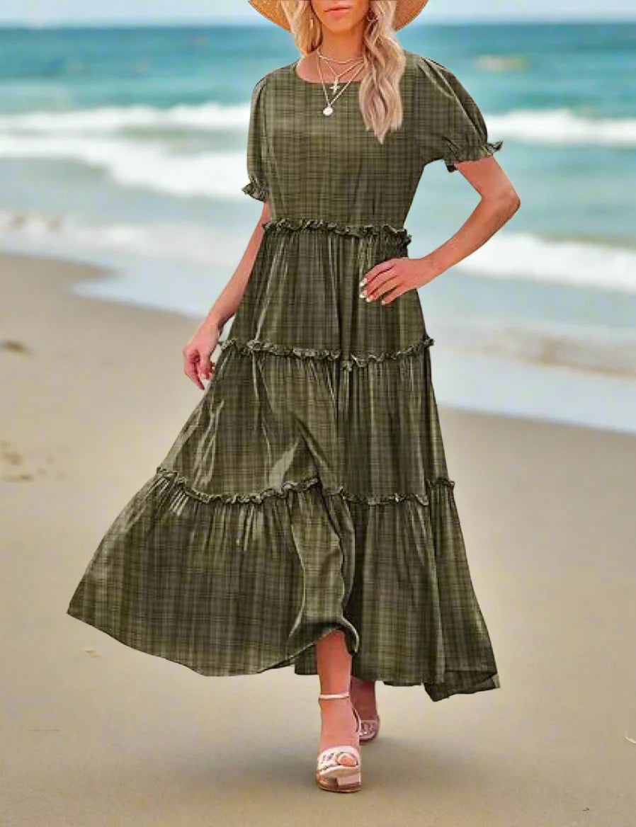 Woman wearing a green plaid dress standing outdoors.