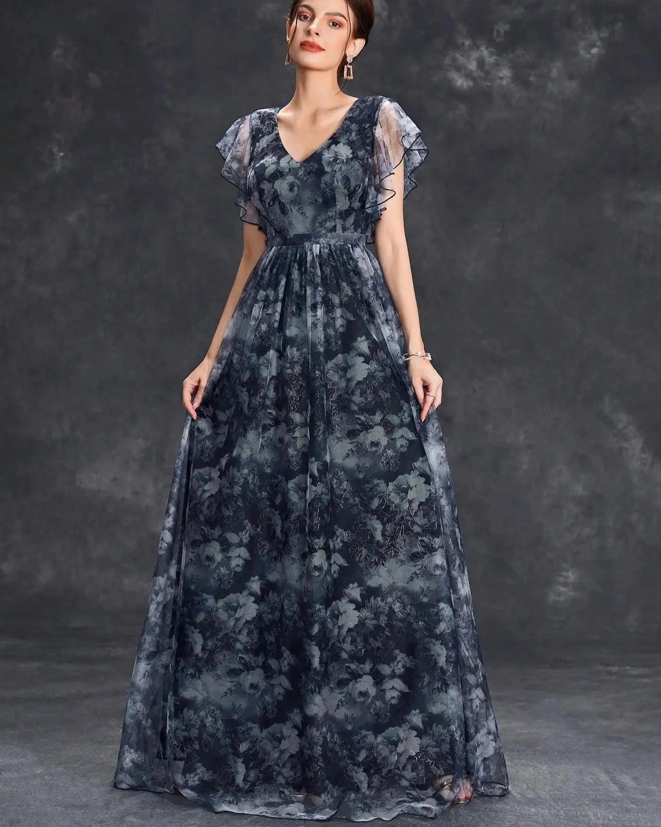 Woman wearing a dark floral dress against a gray background