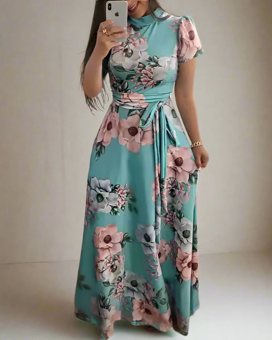 Woman wearing a floral dress taking a mirror selfie in a room