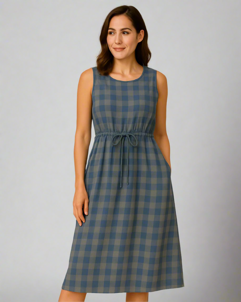 Woman wearing a blue and green checkered dress on a gray background