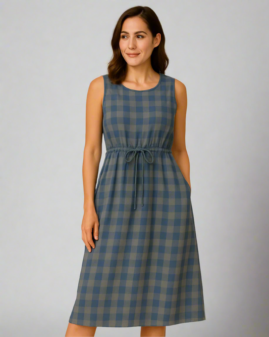 Woman wearing a blue and green checkered dress on a gray background