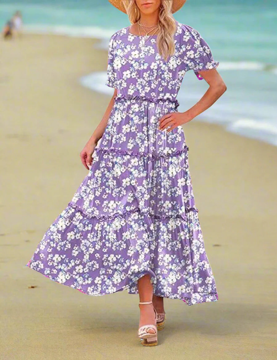 Woman wearing a purple floral dress standing outdoors.