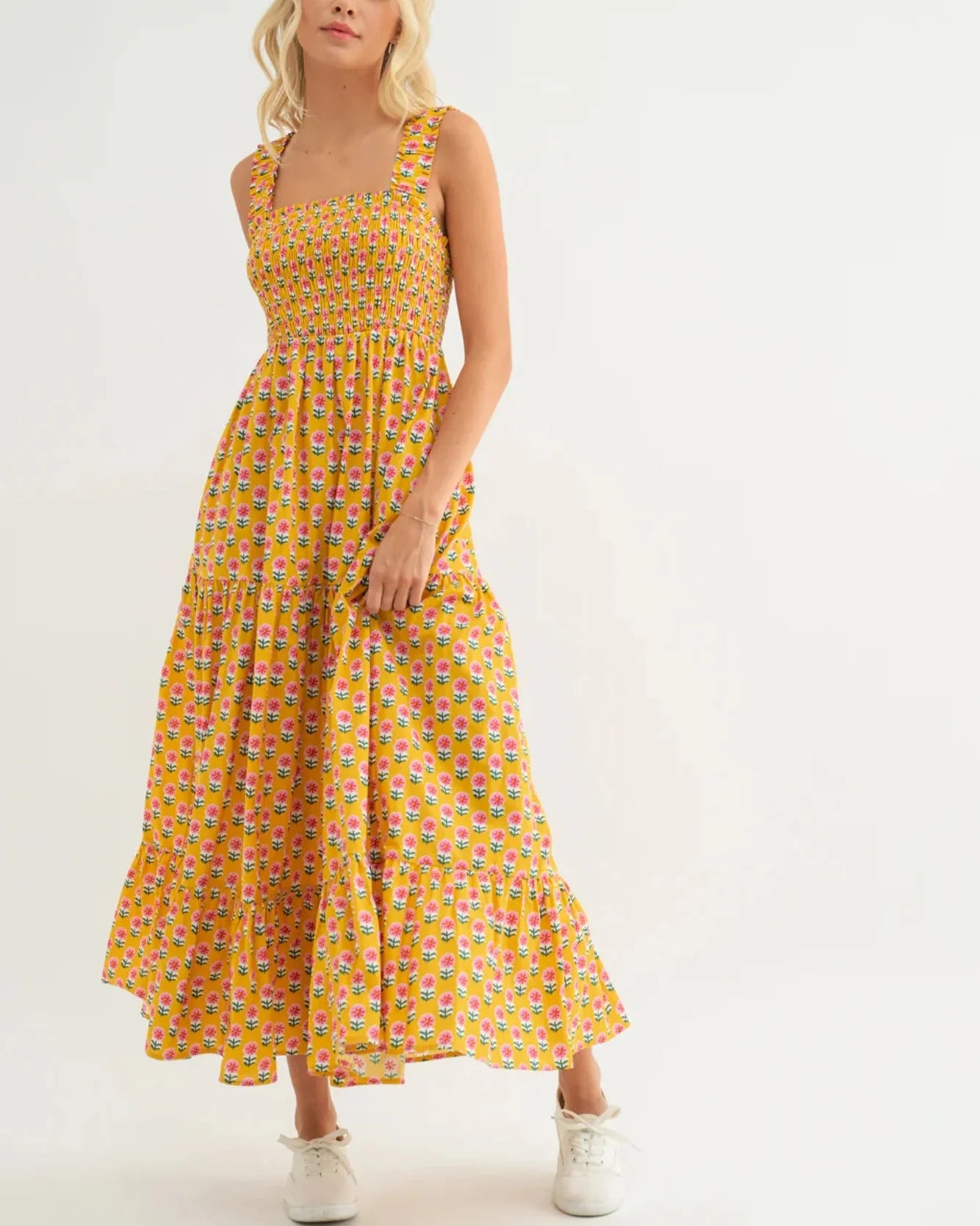 Woman wearing a yellow floral dress on a white background