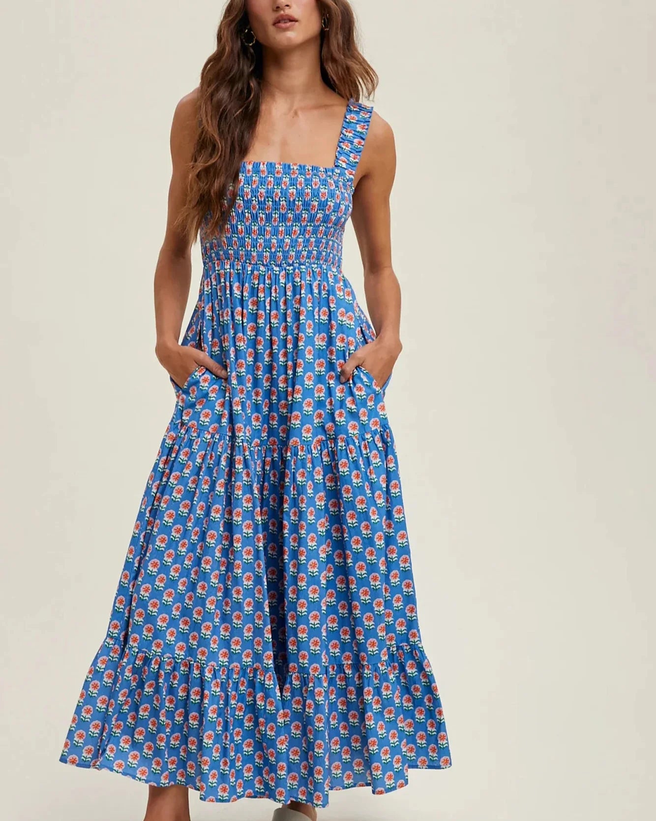 Woman wearing a blue patterned dress on a beige background