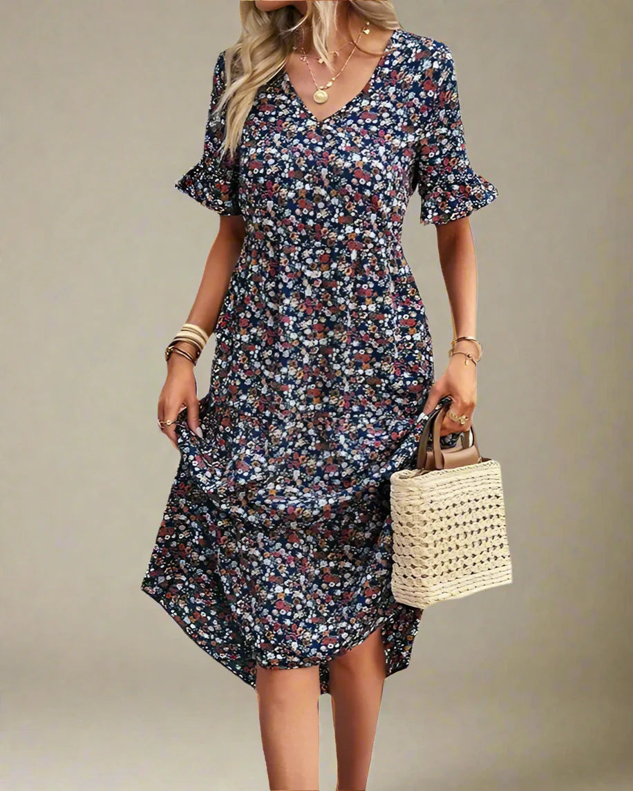 Woman wearing a floral dress holding a straw bag on a white background