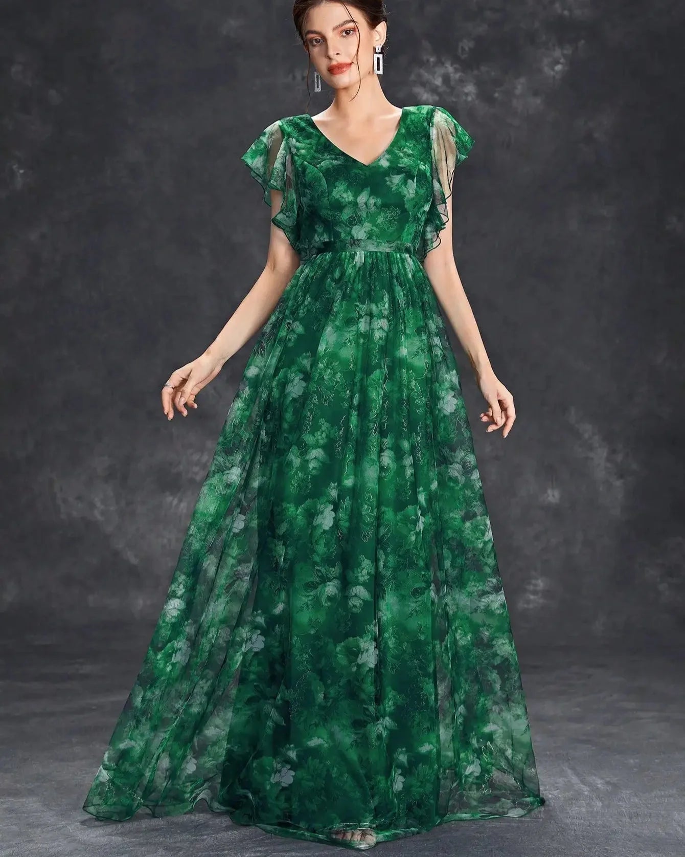 Woman wearing a green floral dress against a dark background