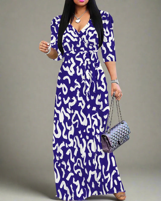 Woman wearing a blue and white patterned dress holding a handbag on a white background