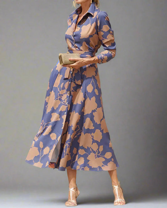 Woman in a blue floral dress standing in front of a wooden door.